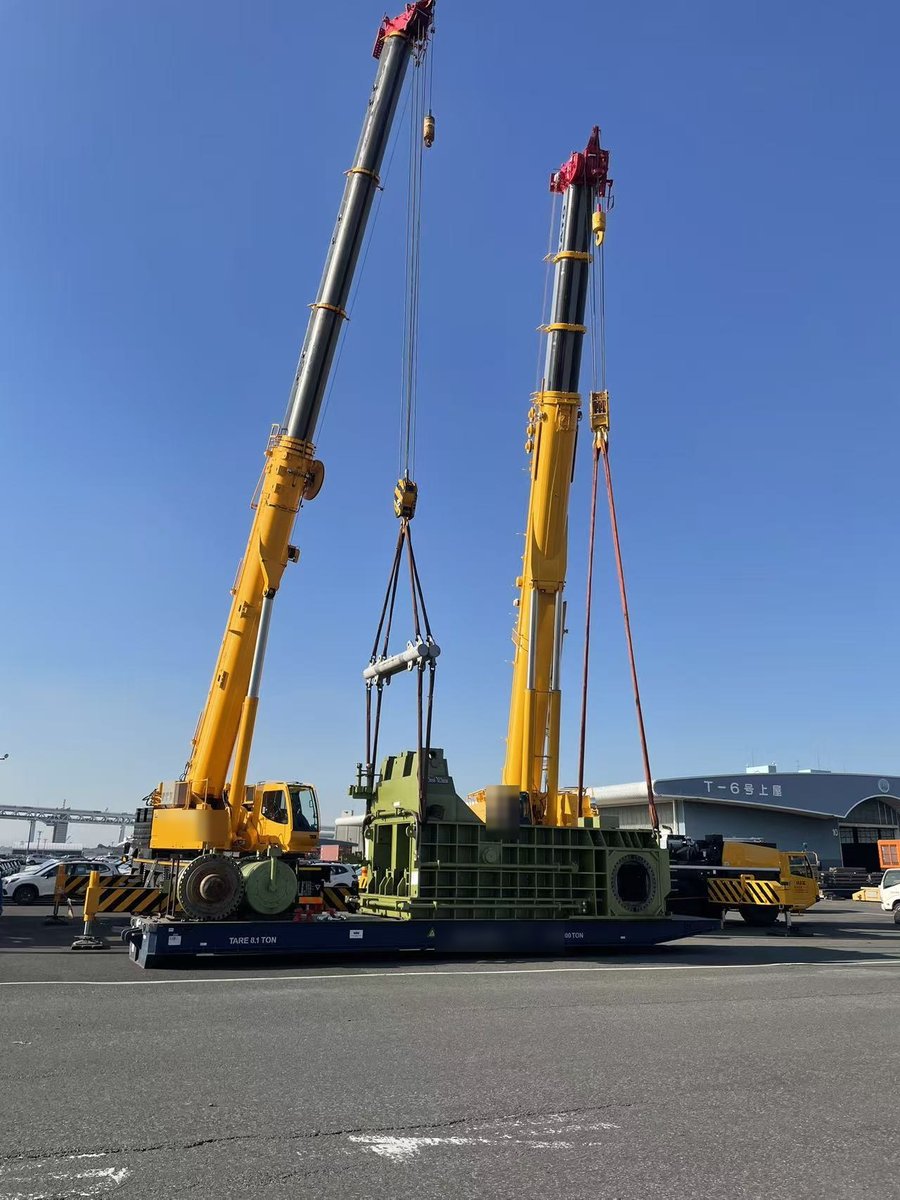 2台の移動式クレーンで大型機械を吊り込み、フラットラックコンテナへ積み付ける作業